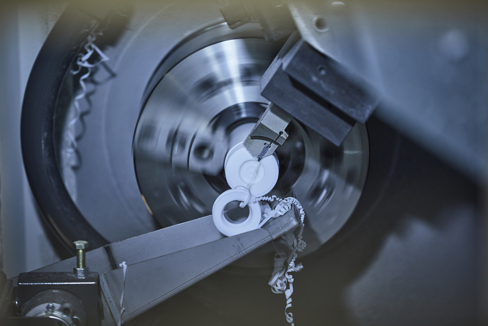 CNC-drejebænk drejer et emne i hvid teknisk plast hos Induflex