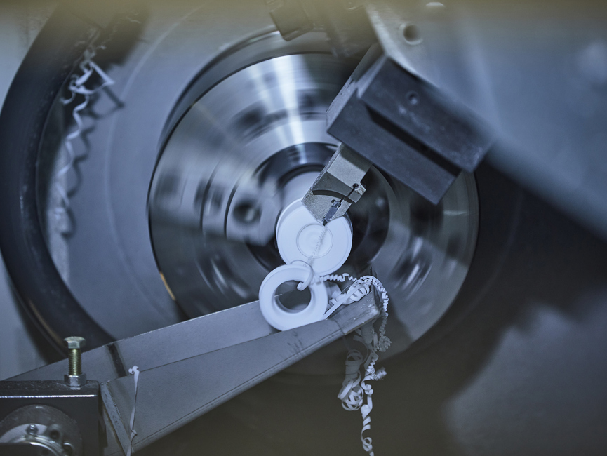 CNC-drejebænk drejer et emne i hvid teknisk plast hos Induflex