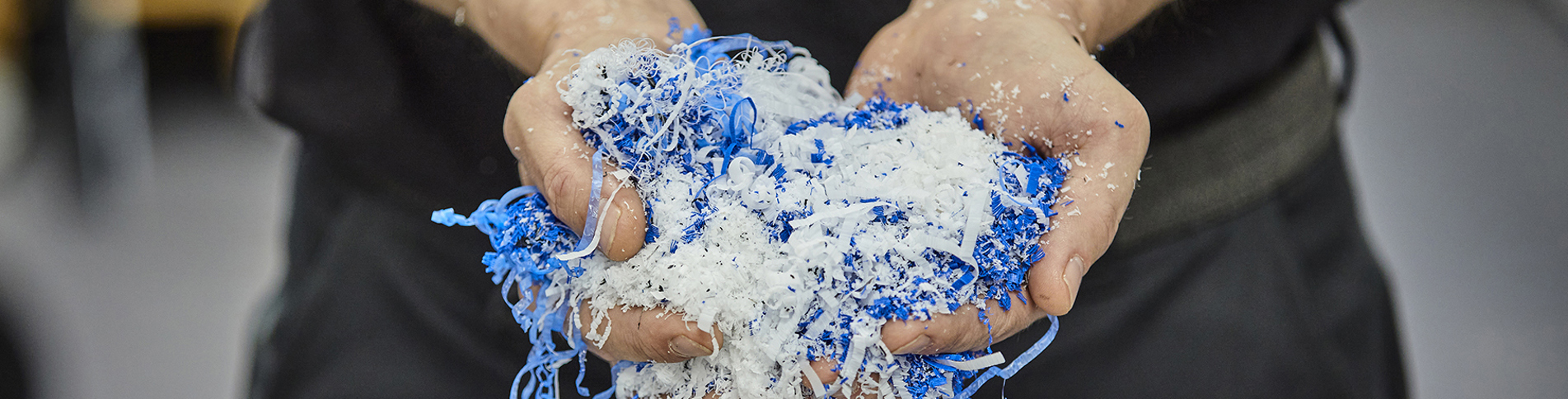 Hands holding chips in blue and white from a cutting processing