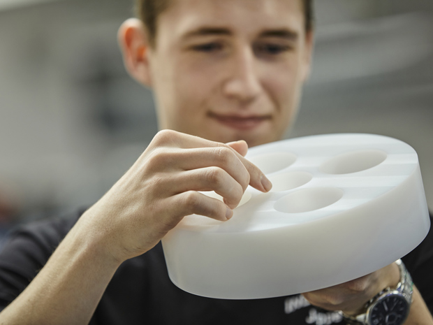 Kvaliteten på drejet emne i hvid POM tjekkes af industritekniker