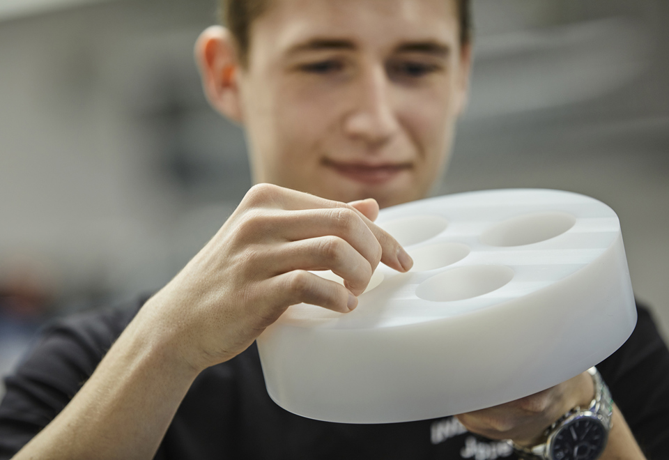 Kvaliteten på drejet emne i hvid POM tjekkes af industritekniker