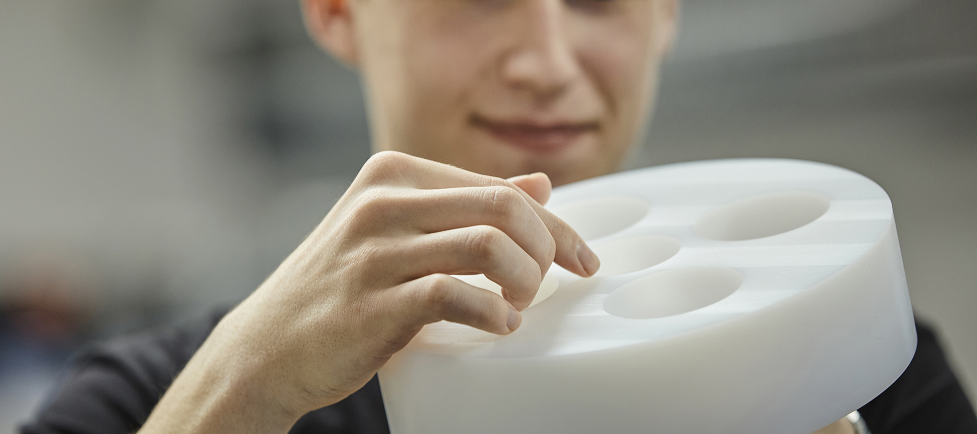 Kvaliteten på drejet emne i hvid POM tjekkes af industritekniker