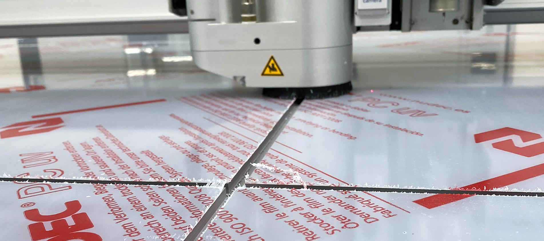 Cutting plotter milling grooving in a clear sheet of polycarbonate