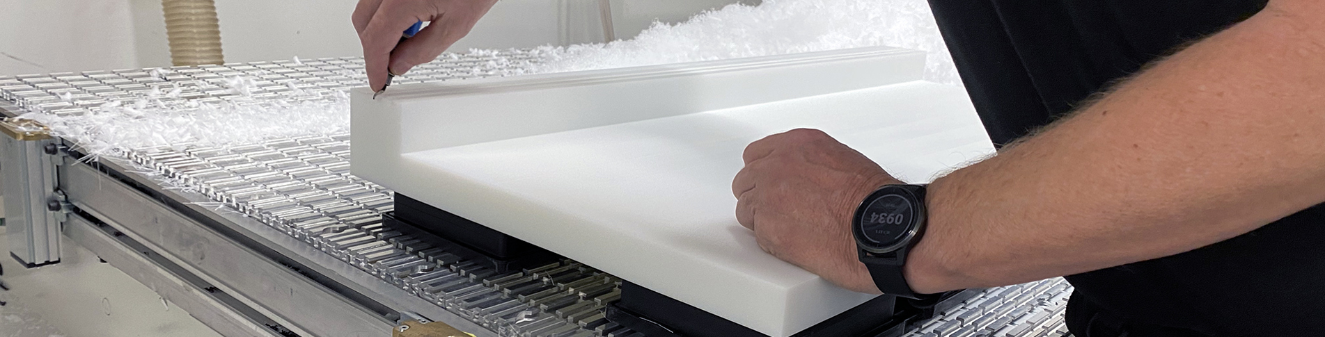 En industritekniker hos Induflex afgrater en maskindel af PEHD