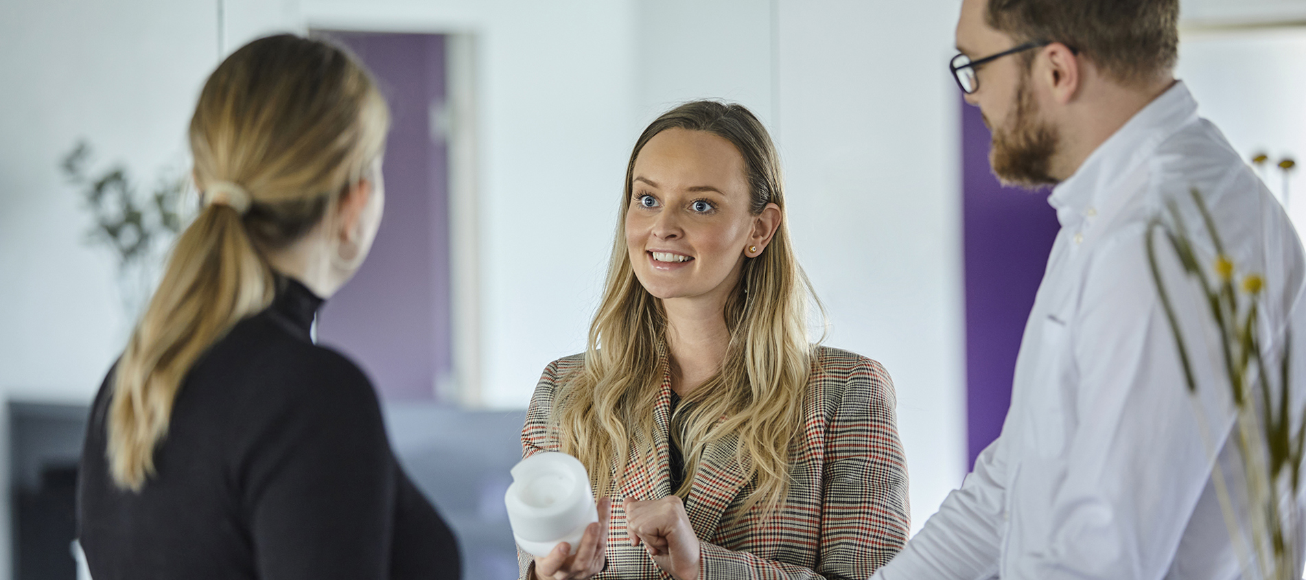 Kundemøde hvor en sælger viser en maskindel i plast frem for en kunde hos Induflex