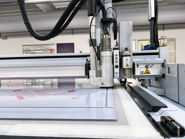 Skæreplotter skærer firkanter ud af en plade af polycarbonat