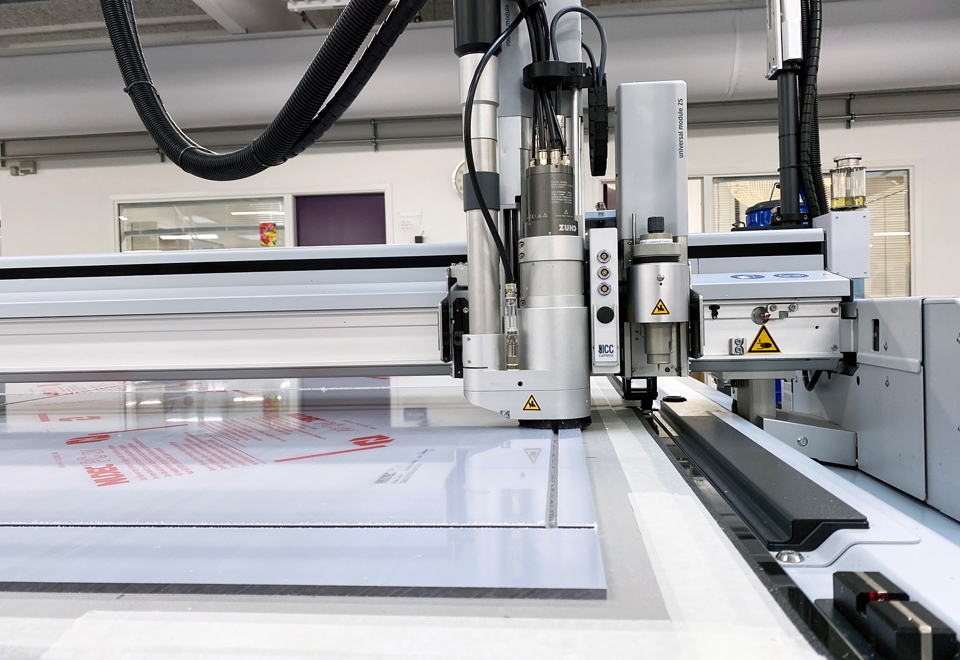 Skæreplotter skærer firkanter ud af en plade af polycarbonat