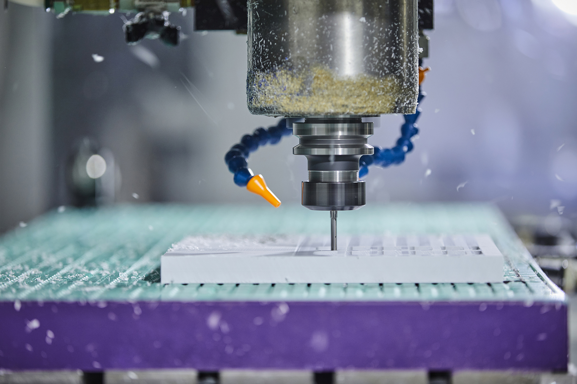 CNC-fræser fræser et emne ud i hvid plast med mange huller