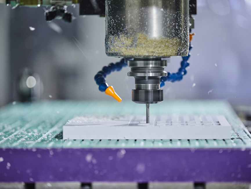 CNC-fræser fræser et emne ud i hvid plast med mange huller