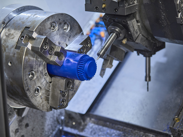 CNC-drejebænk drejer et tandhjul i blå plast med mange takker