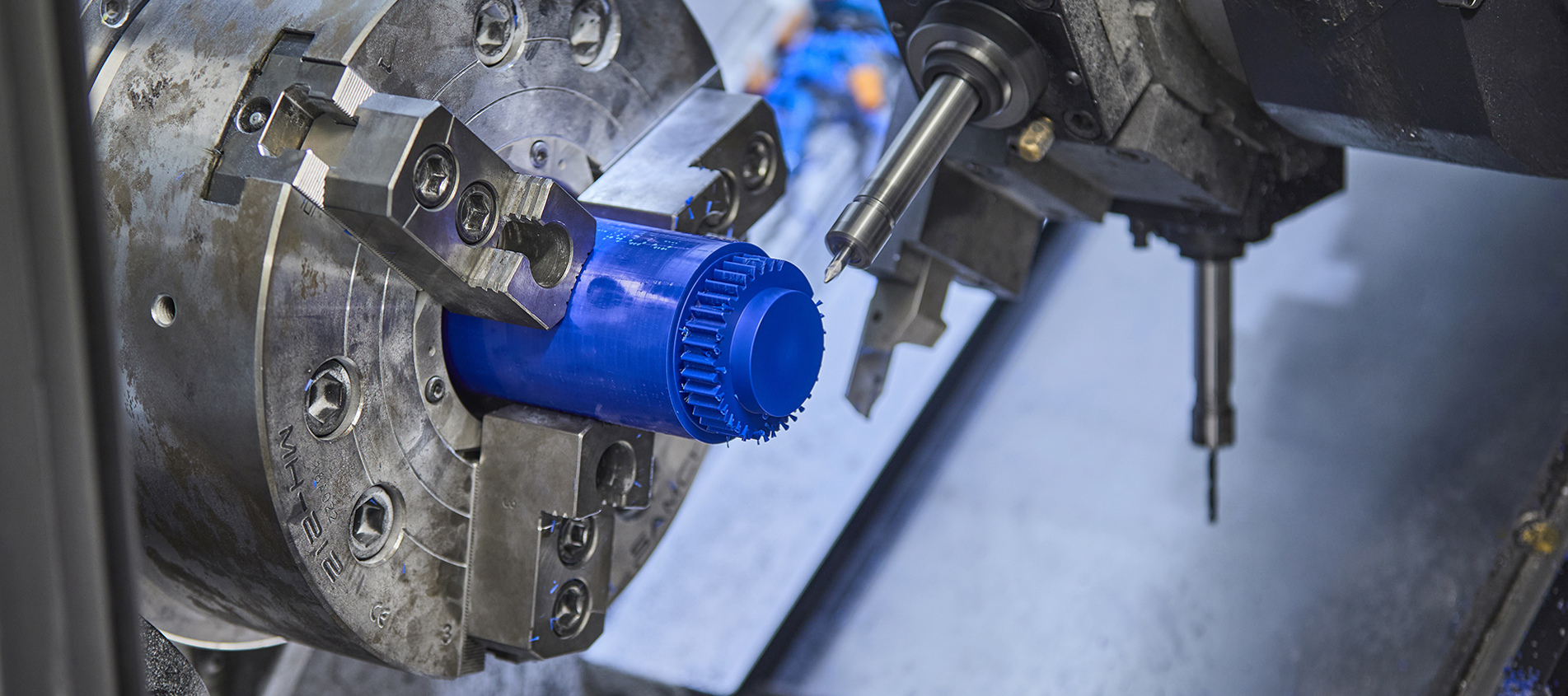 CNC-drejebænk drejer et tandhjul i blå plast med mange takker