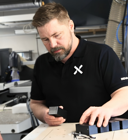 PTA and sales person discuss black plastic component in the production.