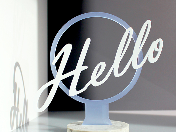 Sign from Induflex in mat blue and white acrylic with the text hello and a foot of grey corian