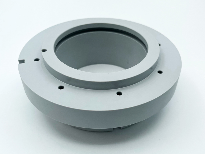 En grå maskindel af PET-P, som er tilsat teflon