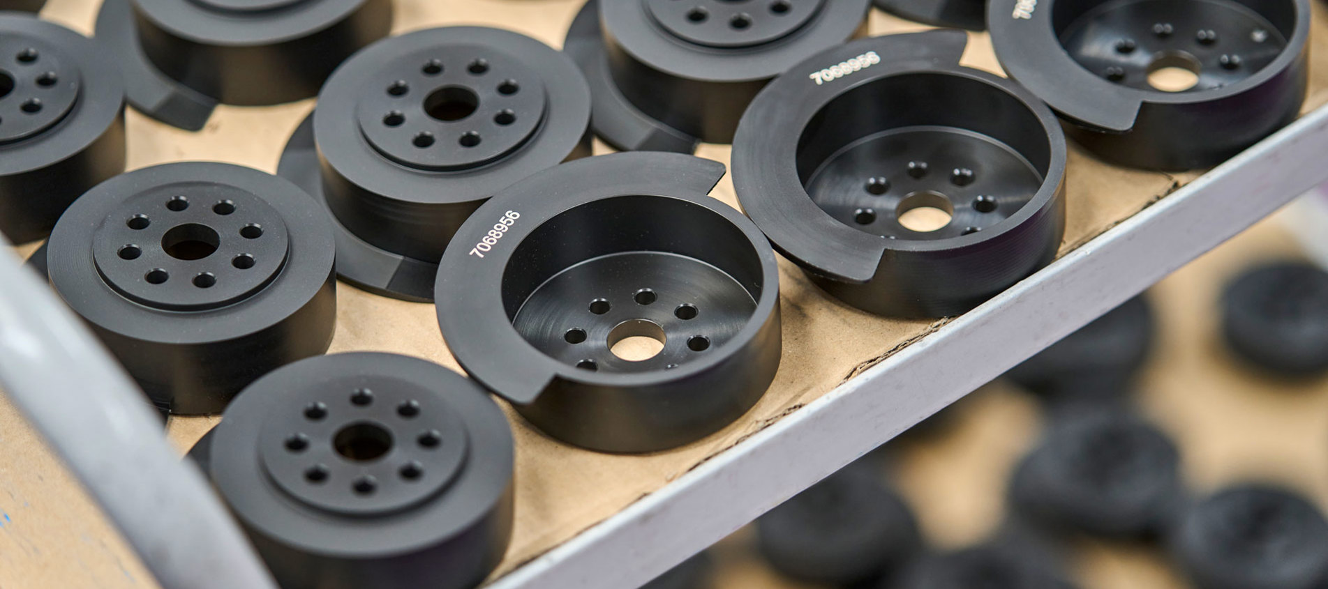 Et rullebord med sorte maskindele med indgraverede tal.