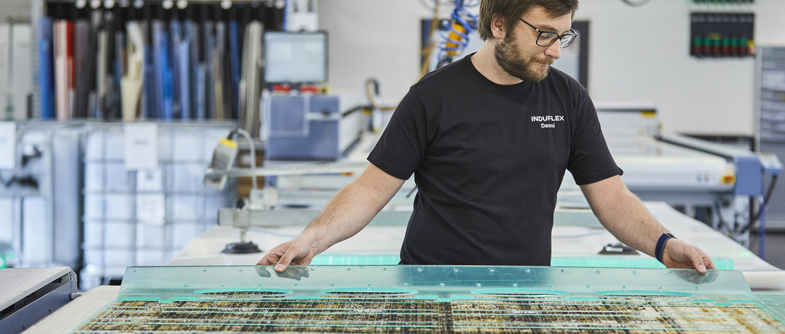 Industry technician changes sheet on a laser cutter with clear acrylic