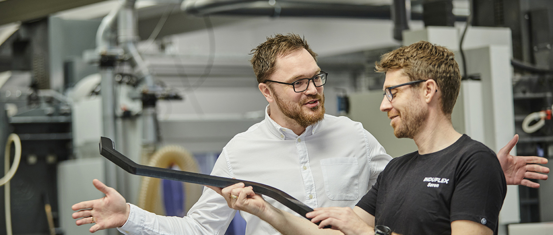 Salgschef og industritekniker taler om et emne i værkstedet hos Induflex