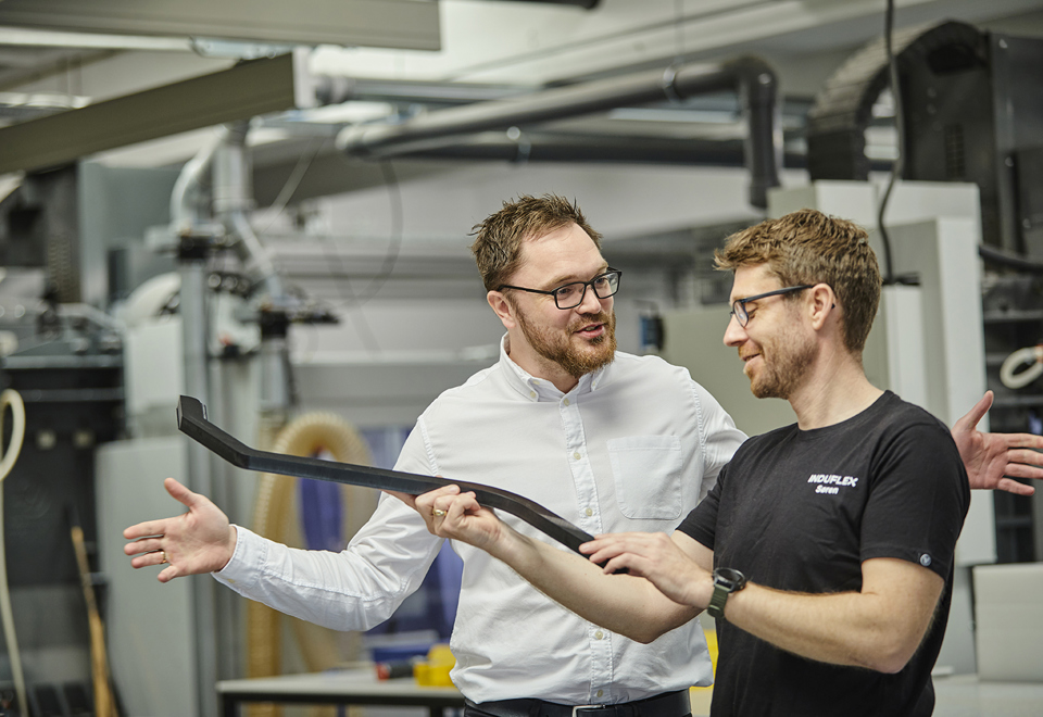 Salgschef og industritekniker taler om et emne i værkstedet hos Induflex