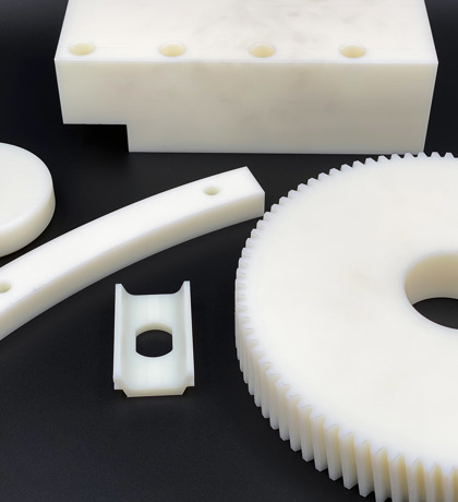 Fem forskellige maskindele lavet af hvidt nylon plast