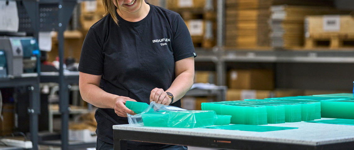 Gennemsigtige emner i akryl pakkes af en lagermedarbejder. 