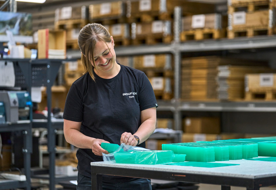 Gennemsigtige emner i akryl pakkes af en lagermedarbejder. 