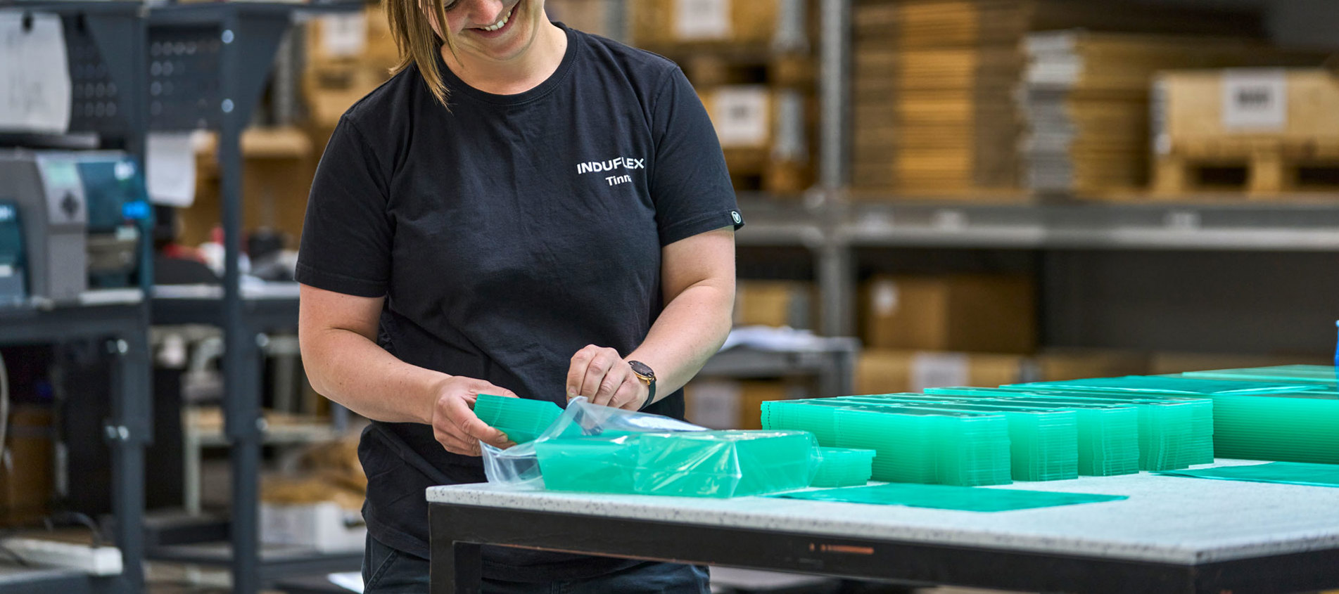 Gennemsigtige emner i akryl pakkes af en lagermedarbejder. 