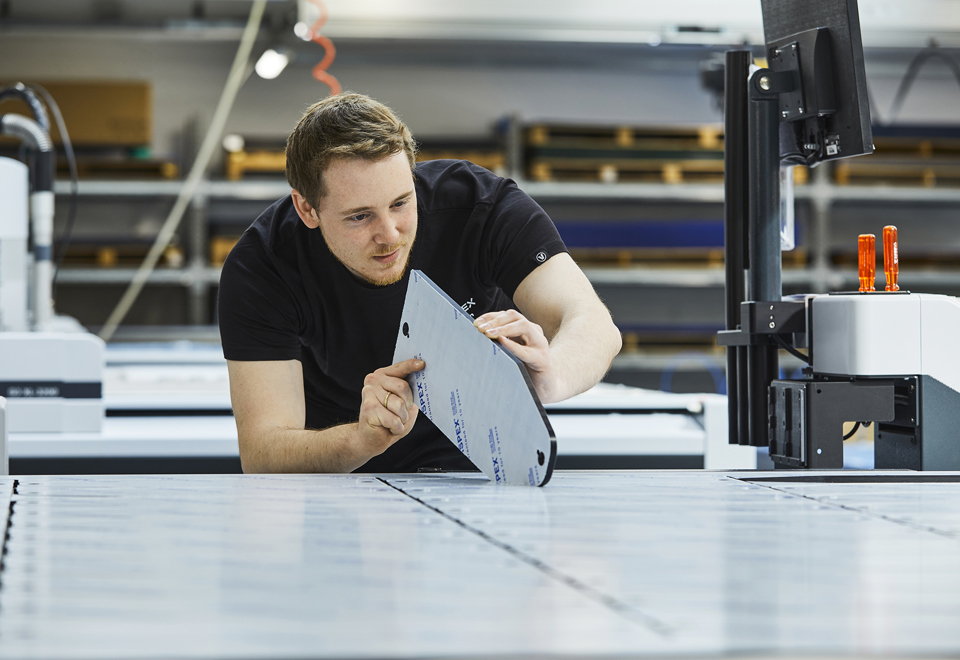 En industritekniker hos Induflex tjekker kvaliteten på snittet på et akrylemne skåret på skæreplotter