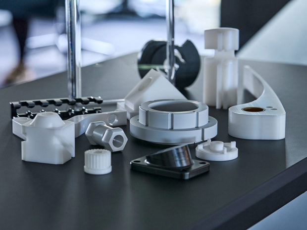 Maskindele i teknisk plast i grå, hvid og sort.