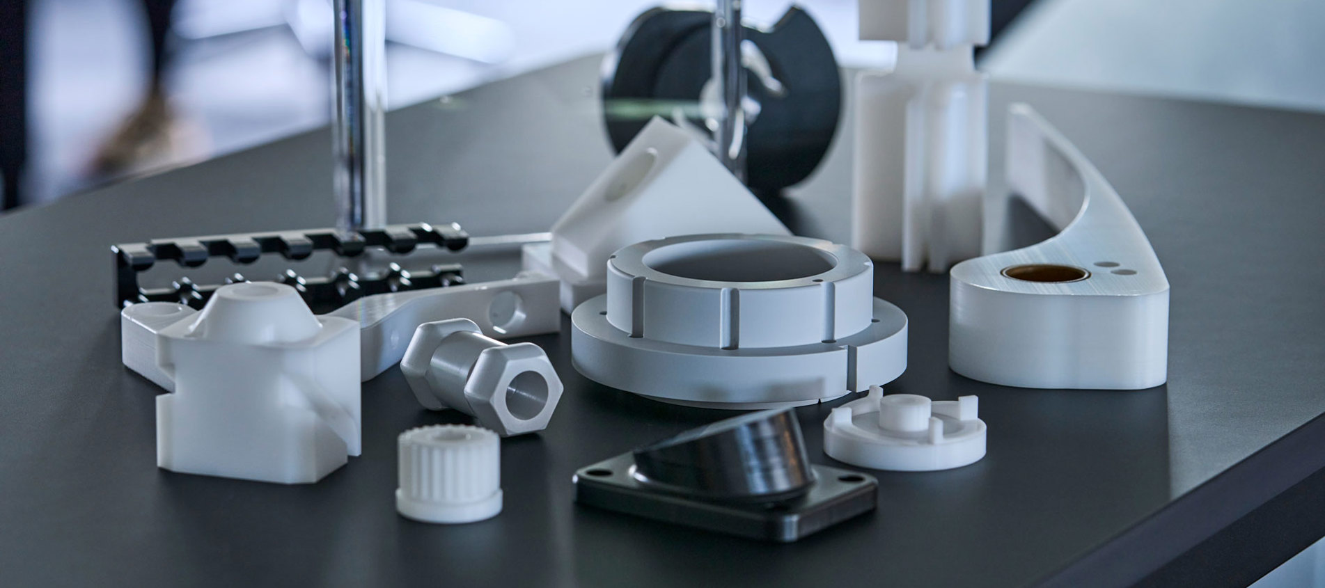 Maskindele i teknisk plast i grå, hvid og sort.