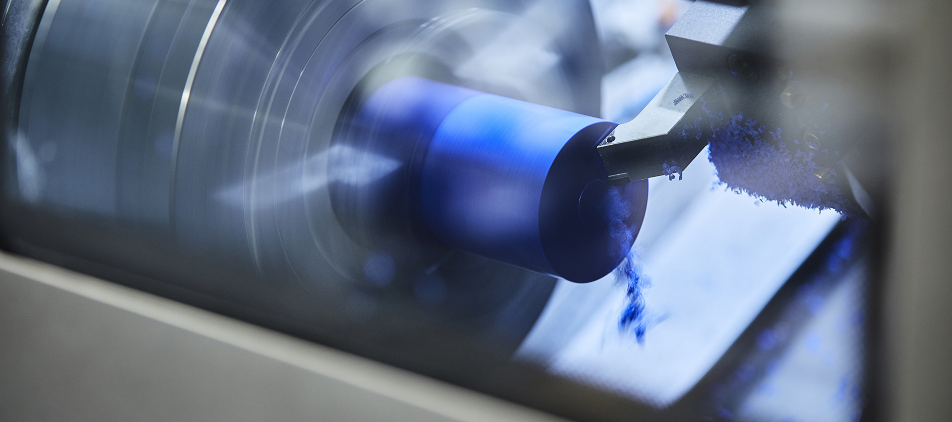 CNC-drejebænk i Induflex' produktion drejer et emne i blåt plast