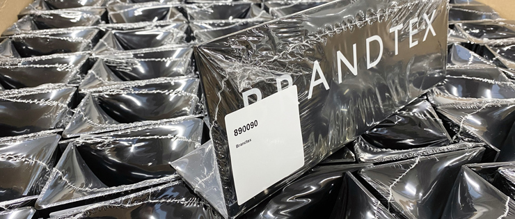 Akrylskilte med logo ligger i kasse klar til forsendelse