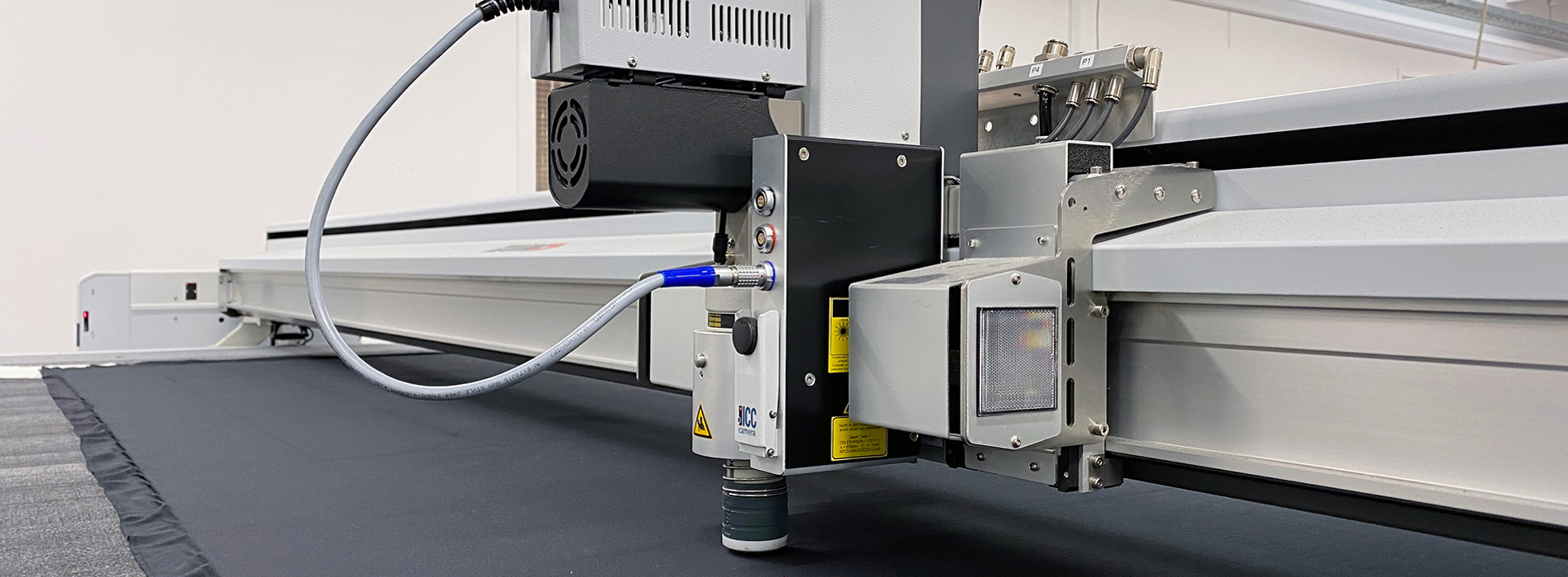 Cutting plotter at Induflex cutting a pattern in a black neoprene cloth