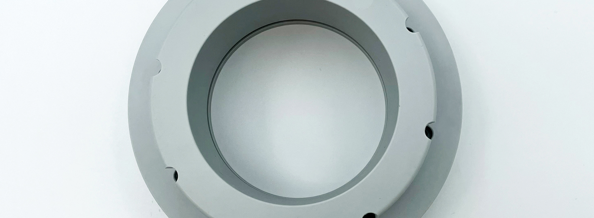 Et gråt PET-P emne, hvor der er tilsat Teflon for at øge glideegenskaberne